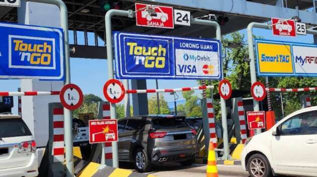 Motorcyclist passing through an open payment toll gate on Penang Bridge